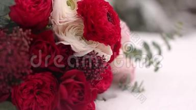 在常<strong>绿</strong>的森林里，婚礼上放着<strong>红白</strong>相间的鲜花。 近景和宏观视野中的嫩玫瑰